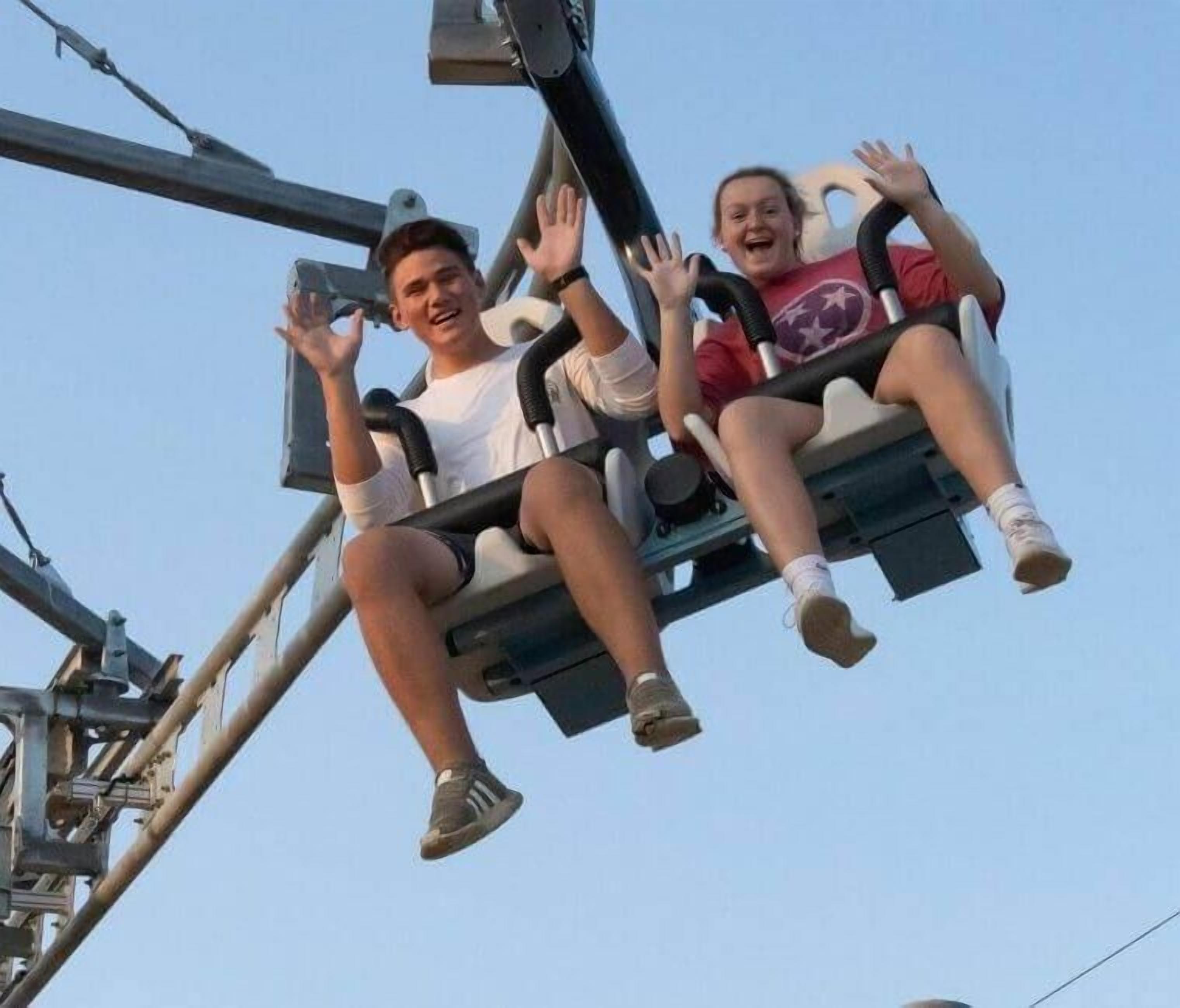 Two people on a swing ride at an amusement park.