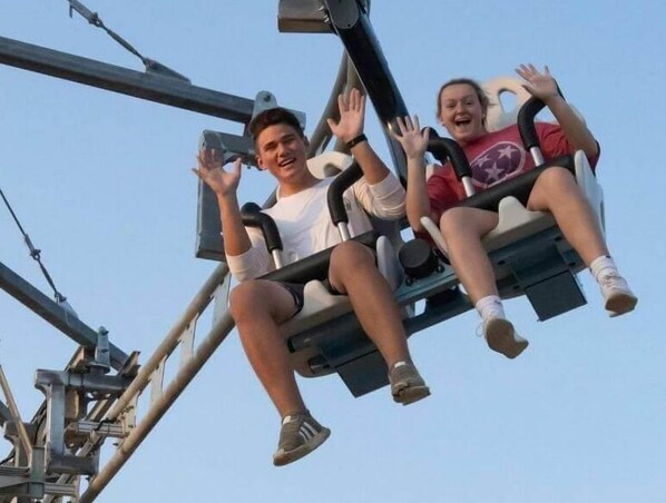Two people on a swing ride at an amusement park.