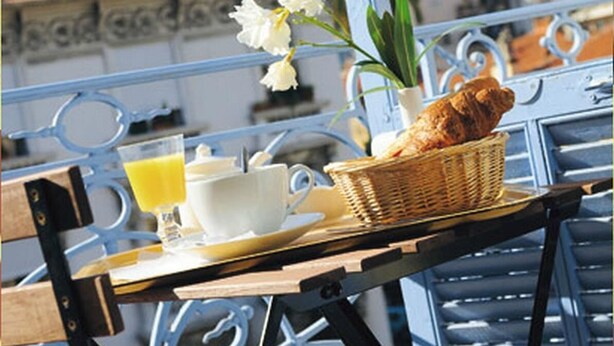 A balcony with a wicker basket containing a croissant, a cup of coffee, and a glass of orange juice. - Villa Saint Hubert (Nice)