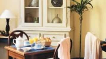 Escritorio, cortinas blackout y tabla de planchar con plancha
