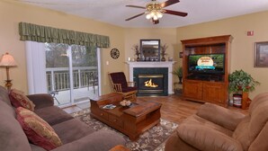 A living room with a fireplace, television, and comfortable seating. - Whispering Pines 331 (Pigeon Forge)