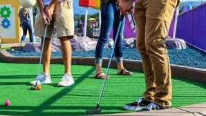 Een minigolfbaan met kunstgras en een putting green.
