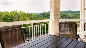 A balcony with a view of a forested landscape. - Whispering Pines 433 (Pigeon Forge)