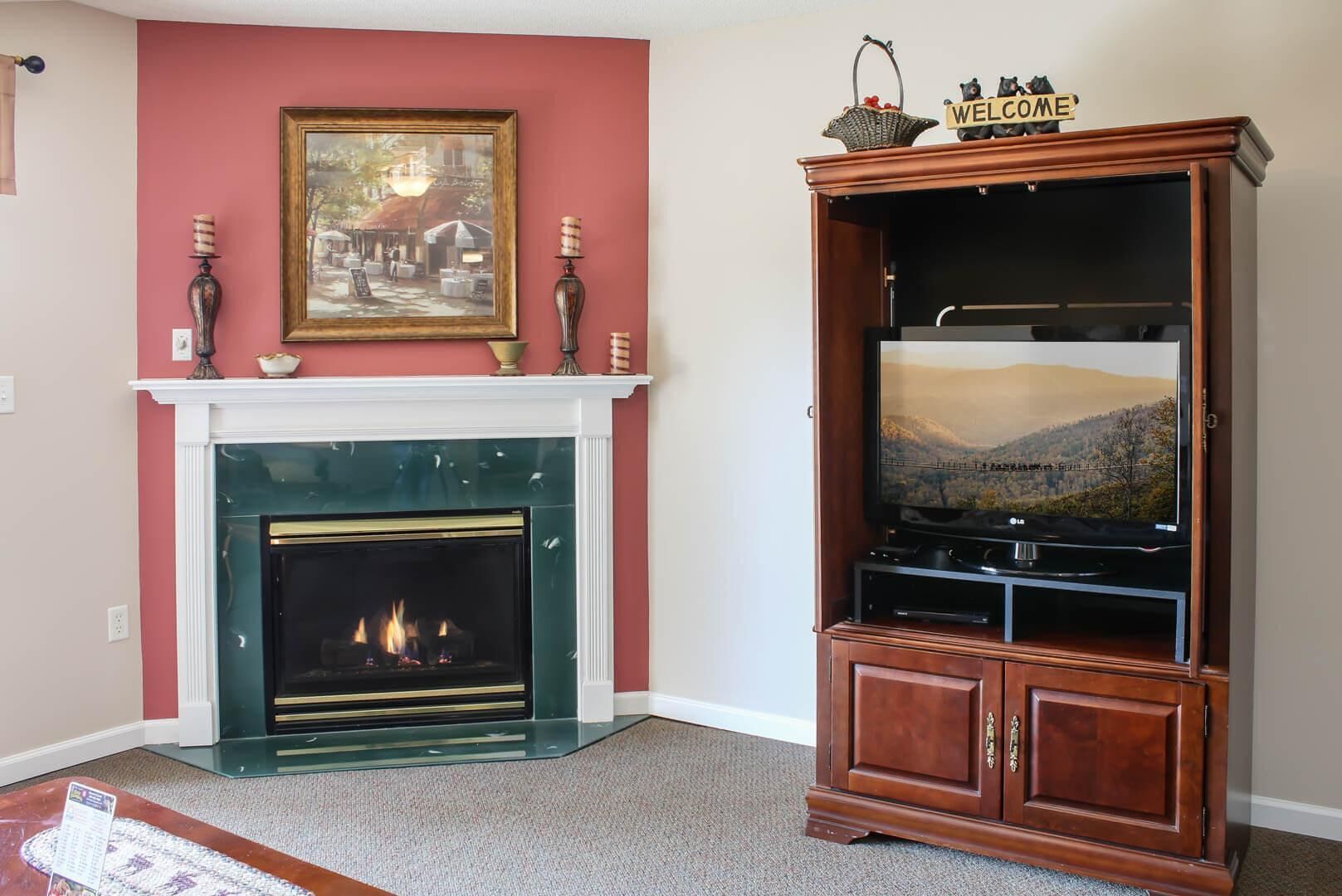 A living room with a fireplace, a television on a wooden stand, and a painting on the wall.
