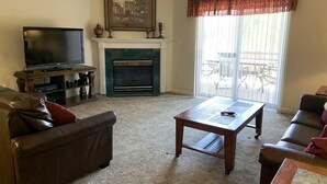Ein Wohnzimmer mit Kamin, Fernseher und einer Couch.