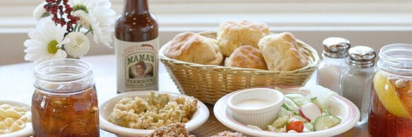 A table with various food items, including a bottle of beer, biscuits, and a salad. - Whispering Pines 454 (Pigeon Forge)