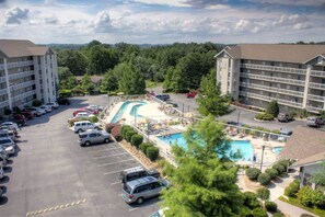A hotel with a swimming pool, parking lot, and multiple buildings. - Whispering Pines 454 (Pigeon Forge)