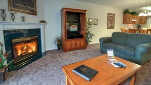 A living room with a fireplace, a television, a sofa, and a coffee table. - Whispering Pines 612 (Pigeon Forge)