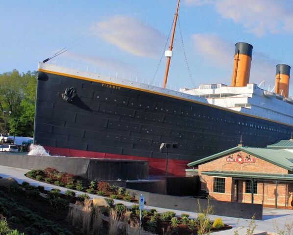 Un vaixell gran amb el nom 'Titanic' al costat, amarrat prop d'un edifici que diu 'White Star'.