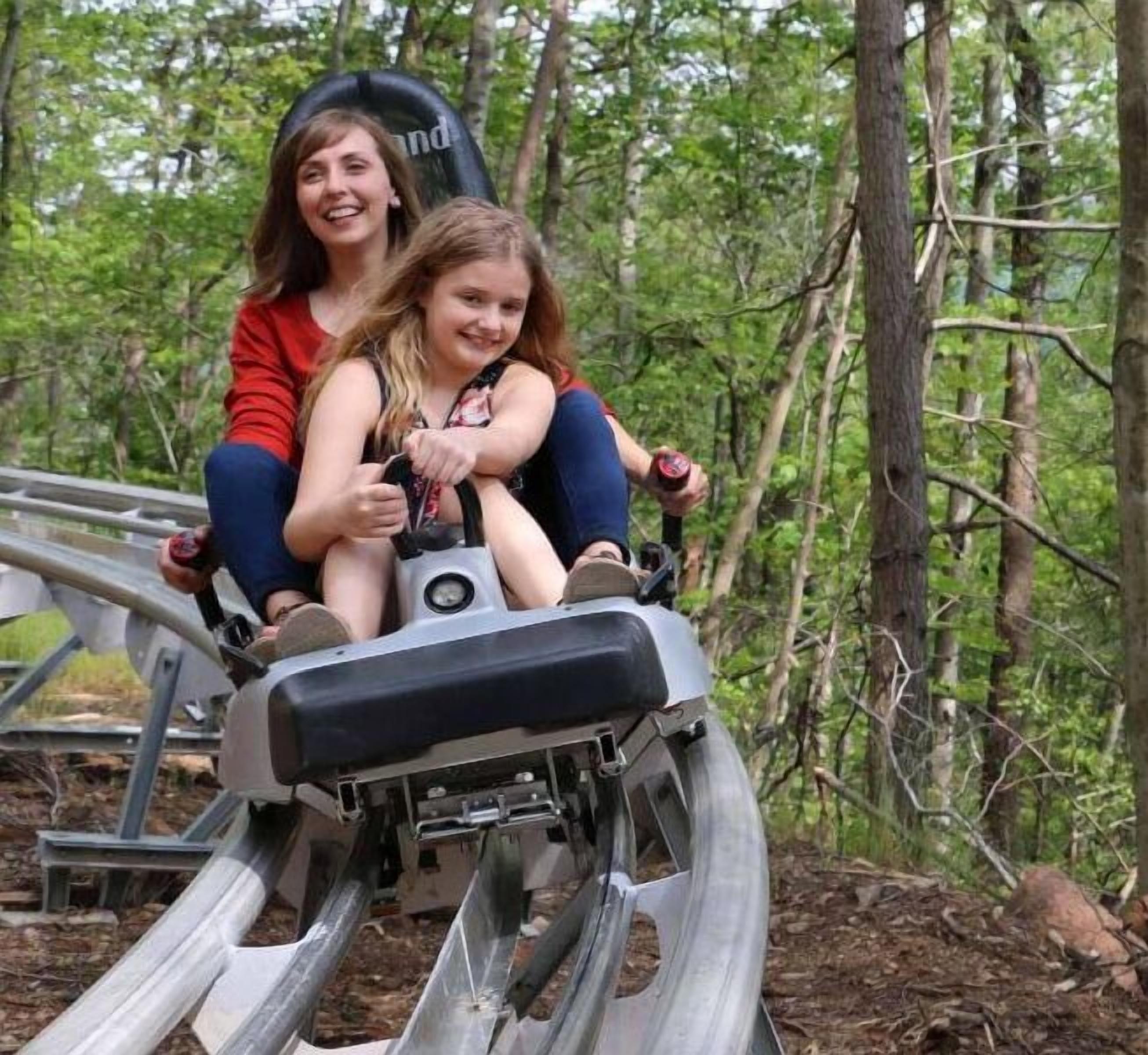 Two people on a ride in a wooded area.