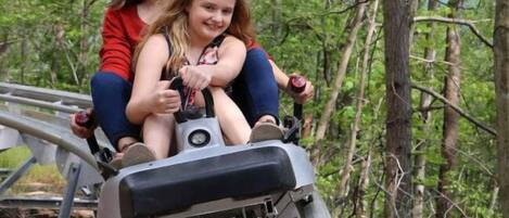 Two people on a ride in a wooded area.