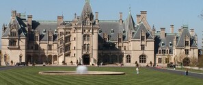 Um edifício grande e histórico com um pátio central e uma fonte.