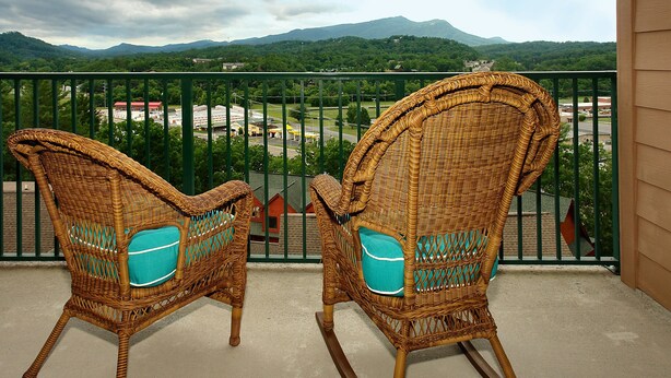 Two wicker rocking chairs with teal cushions on a balcony with a view of a mountainous landscape. - 4002 Big Bear Resort (Pigeon Forge)