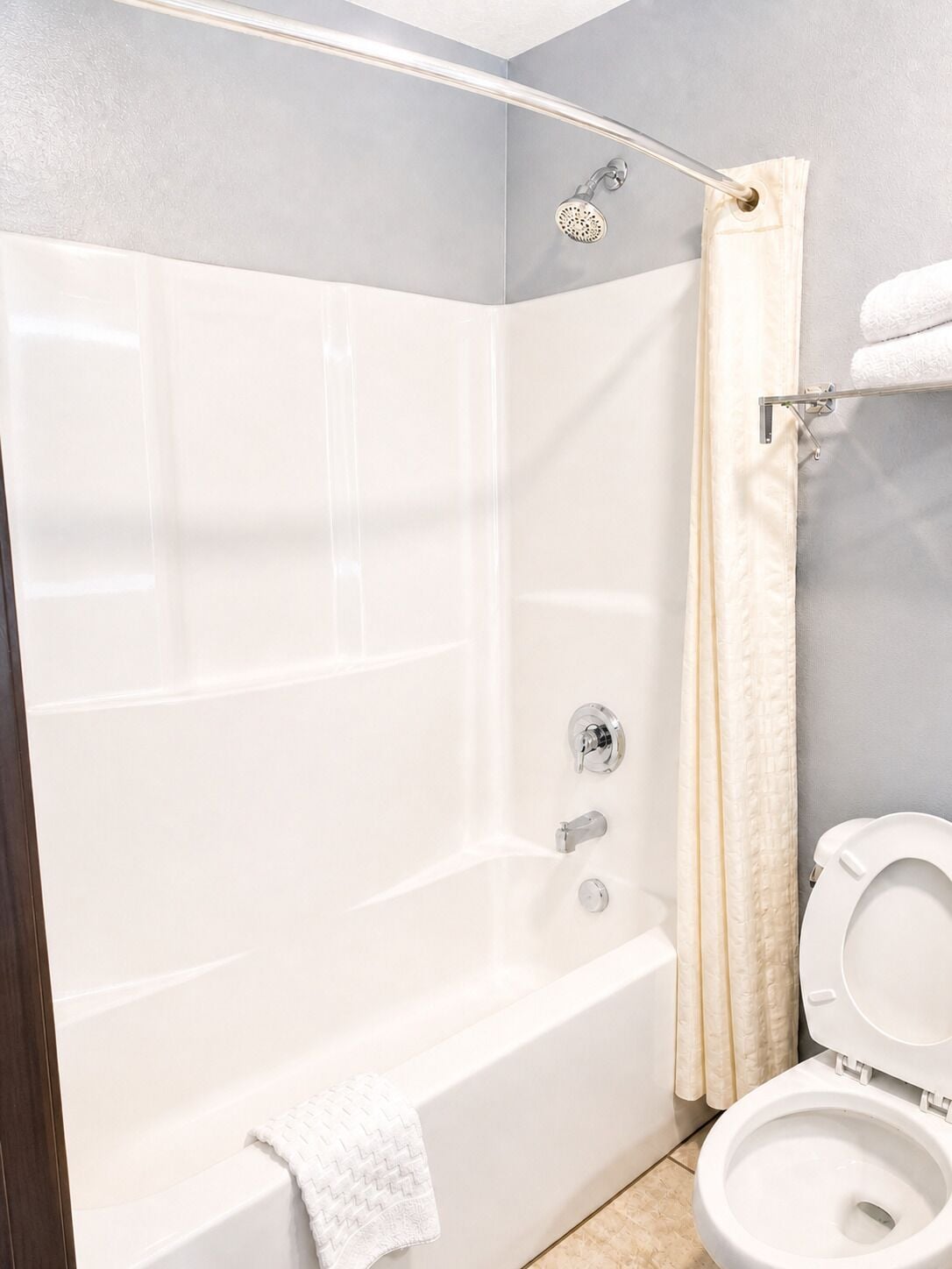 Ein Badezimmer mit Badewanne, Dusche, Toilette und Handtuchhalter.