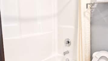 Ein Badezimmer mit Badewanne, Dusche, Toilette und Handtuchhalter.