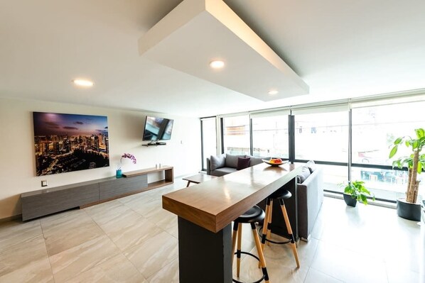 Apartamento básico, 1 cama Queen | Área de estar | TV de tela plana
