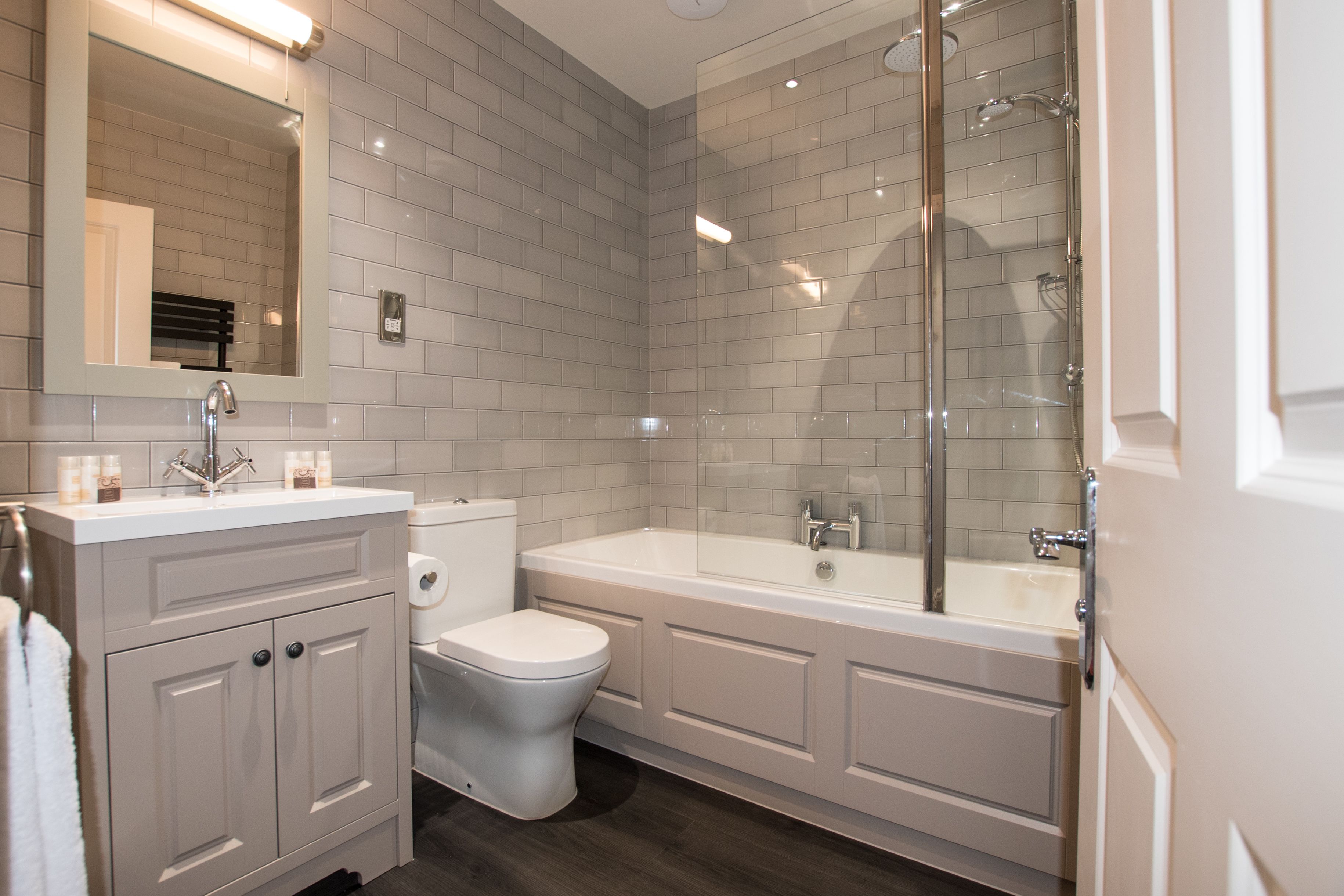 Ein modernes Badezimmer mit Waschbecken, Toilette und Badewanne in Weiß.
