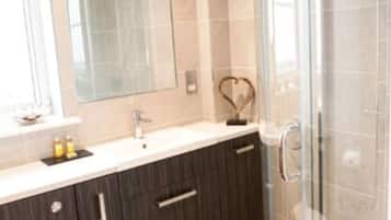 Une salle de bain moderne avec une douche à parois de verre, un meuble-lavabo avec un miroir et des toilettes.