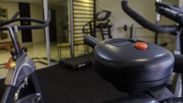 A stationary bike with a control panel and a red button.