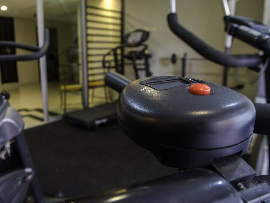 A stationary bike with a control panel and a red button.