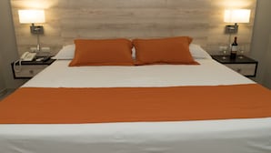 A hotel room with a large bed, two nightstands, a telephone, and two wall-mounted lamps. - Hotel Los Almendros (Manta)
