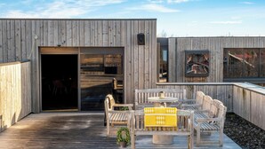 A wooden deck with outdoor furniture, a sliding glass door, and a small outdoor kitchen area. - Hotel Geysir (Bláskógabyggd)