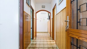 Un pasillo con puertas de madera y suelo de baldosas.