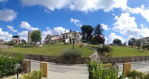 Un quartier résidentiel comprenant une grande maison, un mur en pierre et une pelouse bien entretenue.