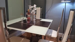 A dining table with two wine glasses, a bottle, and decorative items. - Crossroad Bungalow (Paisley)