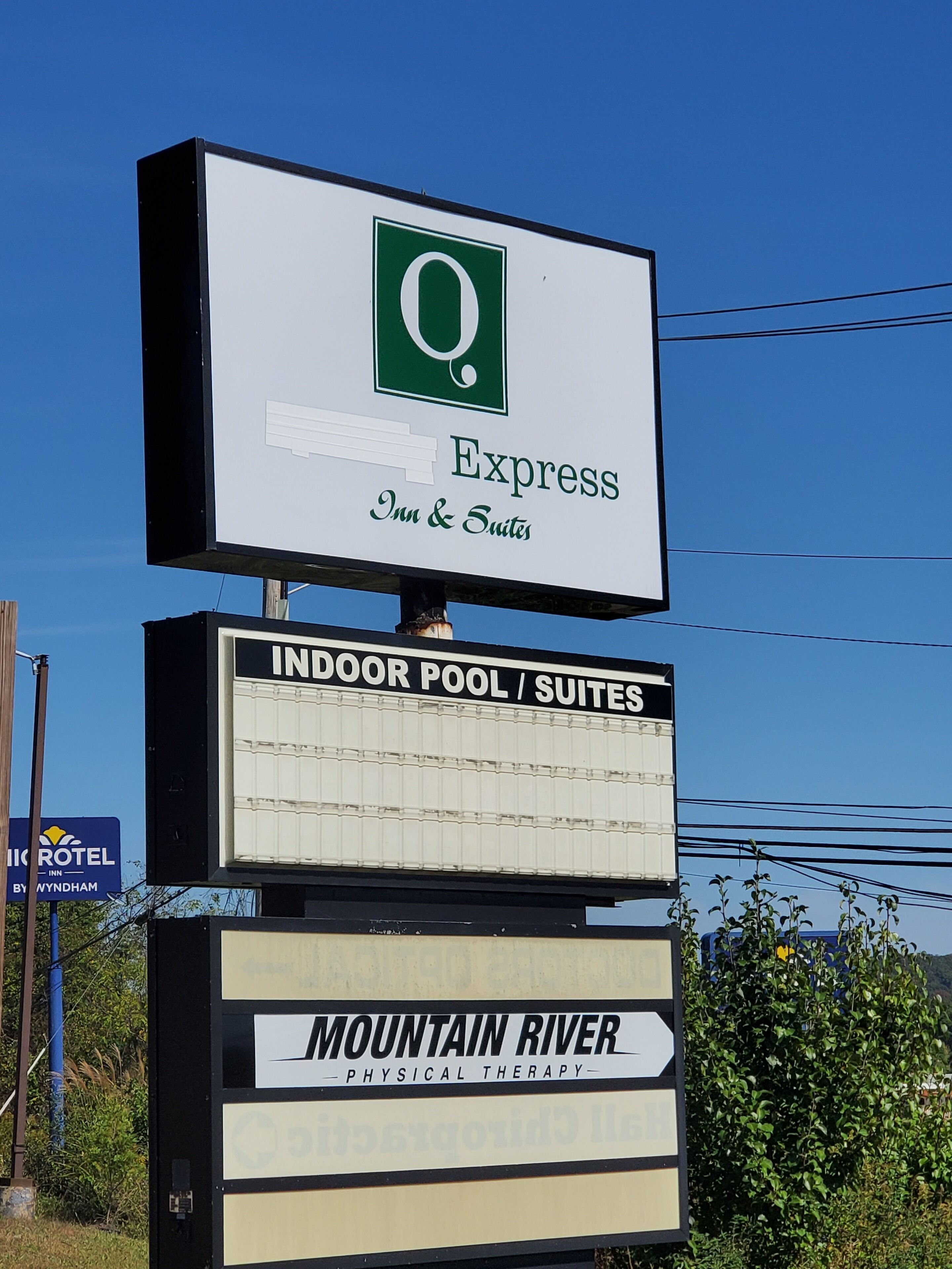 Une enseigne d’hôtel indiquant « Express Inn & Suites » et « Piscine intérieure / Suites », ce qui renseigne sur les équipements disponibles.