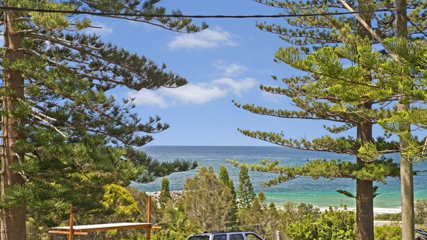 A coastal view with a clear sky, a beach, and dense green trees. - Quarterdeck 7, 7 Stewart Street (Port Macquarie)