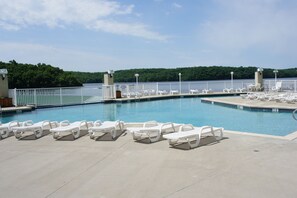 A pool area with white lounge chairs and a view of a forested area. - 9104 Towers, Fantastic lake views!  STILL AVAILABLE FOR SHOOTOUT RACE WEEKEND (Osage Beach)