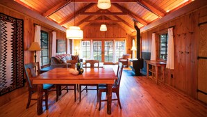 A spacious wooden dining area with a high ceiling and large windows. - Corkins Lodge (Chama)