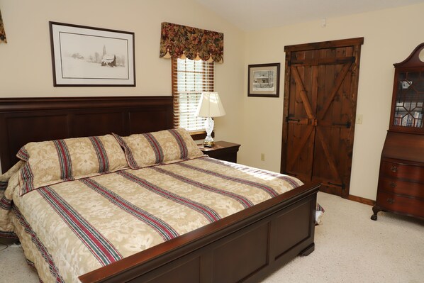 A bedroom with a large bed, a nightstand, a dresser, and a window with blinds. - Peaceful 3BR 2.5 Bath Home Near Sparta NC & Blue Ridge Parkway Sleeps 6 (Glade Valley)