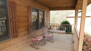 A wooden porch with two rocking chairs and a bench, featuring a wooden railing and a view of the surrounding area. - Peaceful 3BR 2.5 Bath Home Near Sparta NC & Blue Ridge Parkway Sleeps 6 (Glade Valley)