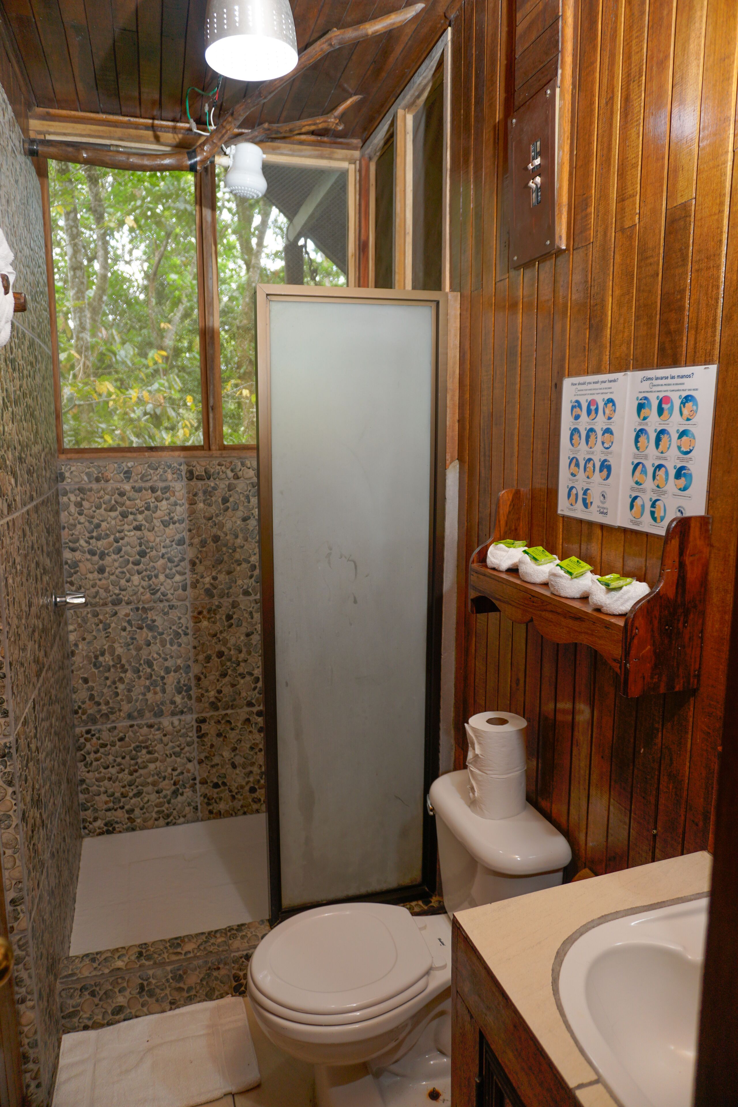 A bathroom with a shower, toilet, and sink.