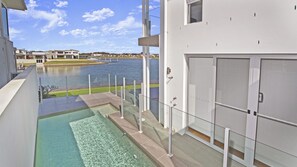 En moderne bygning med en pool og udsigt til vand.