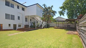 A two-story residential building with a covered porch and a staircase leading to the upper floor.