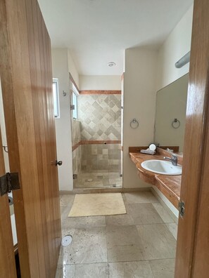 Une salle de bain avec une douche, un lavabo et un miroir.