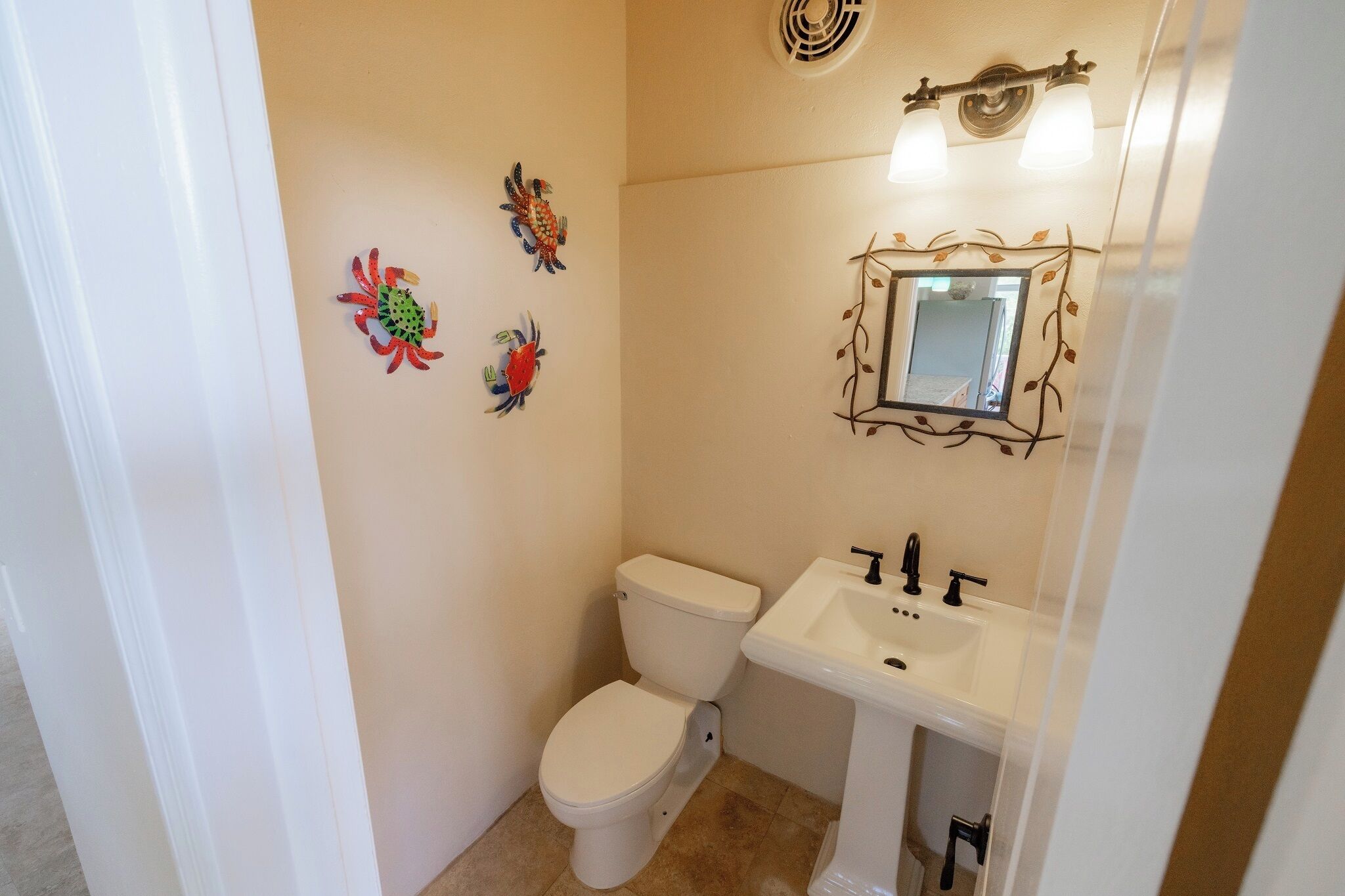 A bathroom with a toilet, sink, and decorative wall art.