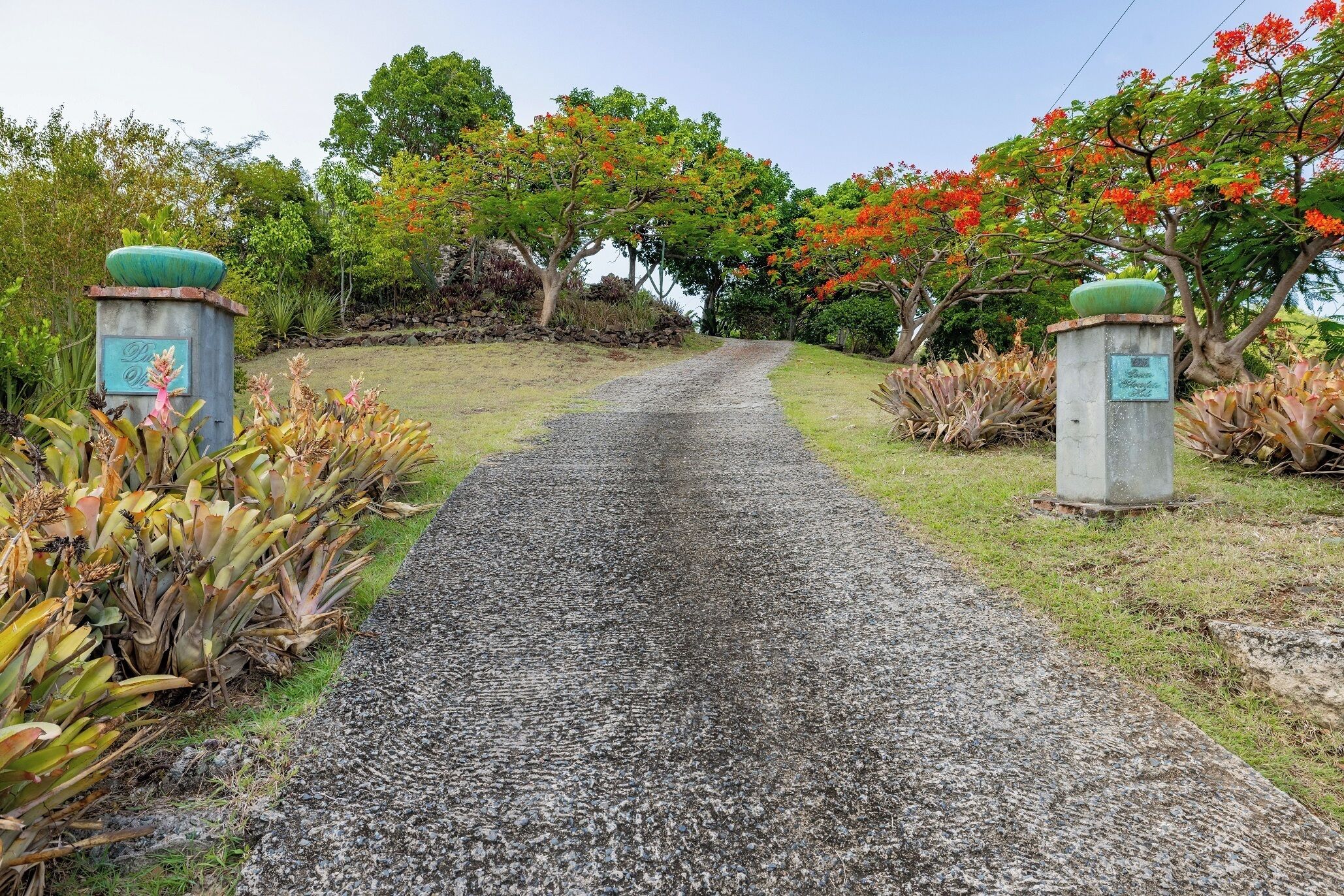 A gravel pathway leading to a building entrance with a plaque on each side.