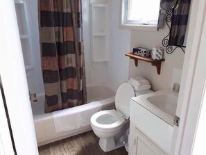 Ein kleines Badezimmer mit Toilette, einer Badewanne und einer Duschkabine.