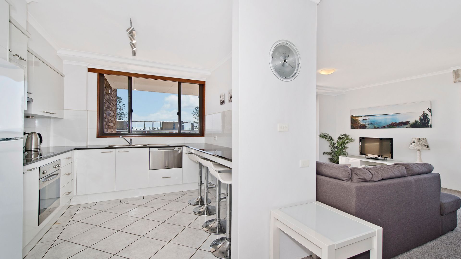 A modern apartment with a kitchen, dining area, and living room.