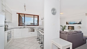 A modern apartment with a kitchen, dining area, and living room. - Akuna 18, 6 Joffre Street (Port Macquarie)