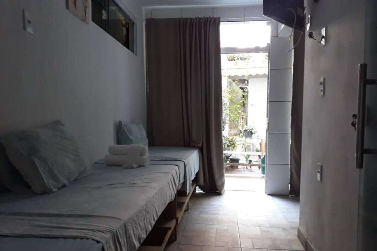 Une chambre à coucher avec un lit, une petite table et une porte donnant sur un balcon.