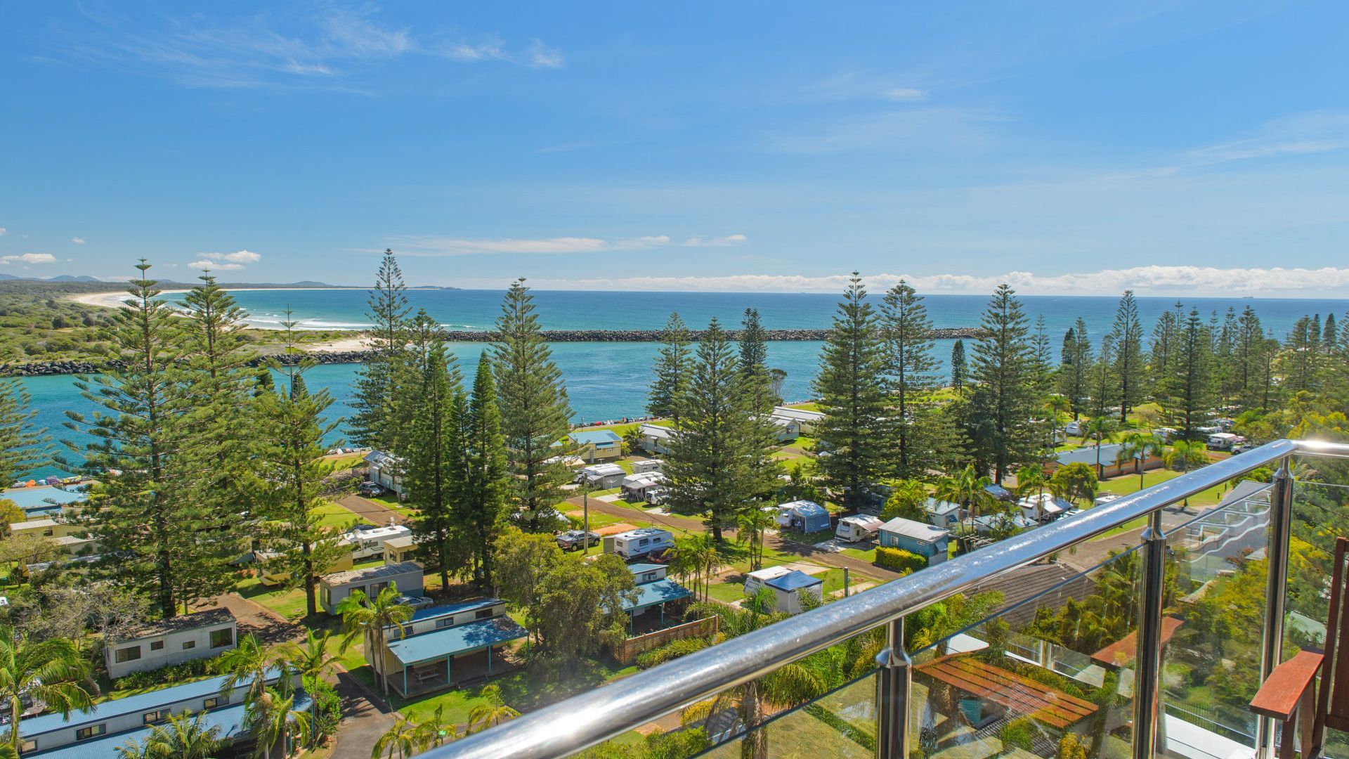 Ein Küstenresort mit mehreren Holzhütten, einem Strand und Blick aufs Meer.