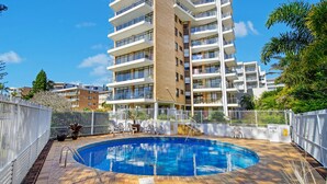 A residential building with a swimming pool, multiple balconies, and a fenced area. - Tasman Towers 5, 3 Munster Street (Port Macquarie)
