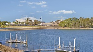 A waterfront property with a dock, a building with a white roof, and a flagpole. - Dolphins 2, 7 Commodore Crescent (Port Macquarie)