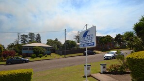 A residential area with a house, a driveway, and a signboard advertising vacancy.