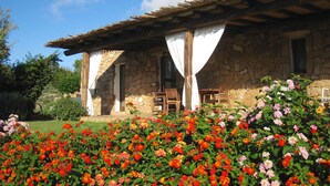 Un bâtiment en pierre avec un toit en tuiles et un porche abrité.